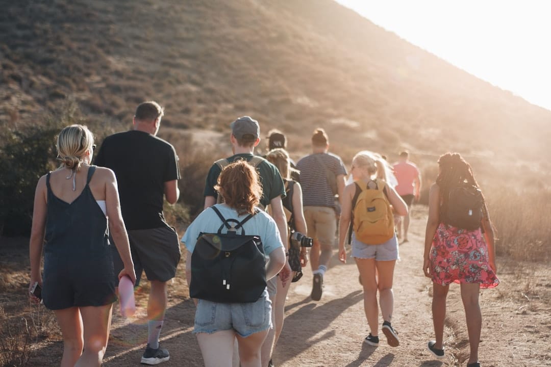 Photo by Luke Porter people walking on dirt road near mountain during daytime